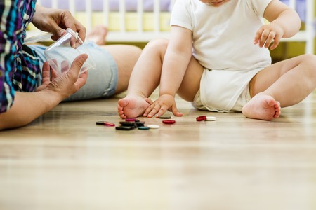 happy father and his little daughter playing with various buttons at homeの写真素材