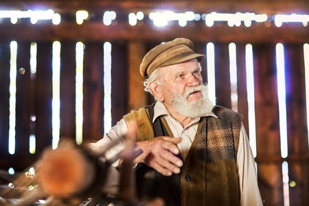 Portrait of old farmer with beard and hat