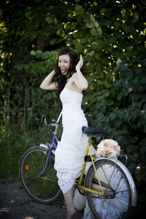 Bride in white wedding dress on retro bicycleの写真素材