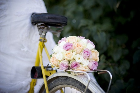 Close-up of bride in white wedding dress on retro bicycleの写真素材