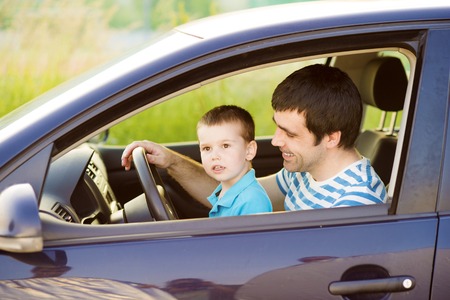 Young father with his little son driving car togetherの写真素材