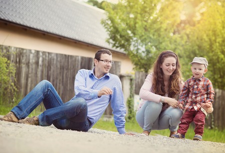 Little boy playing outside with his parents