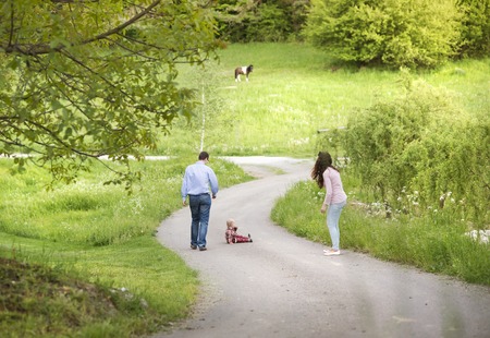 Happy family playing with son in green natureの写真素材