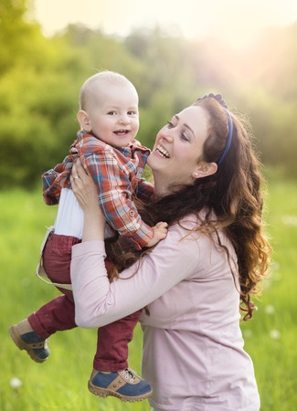 Happy young mother having fun with her son in natureの写真素材