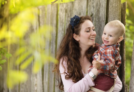 Happy young mother having fun with her son in natureの写真素材