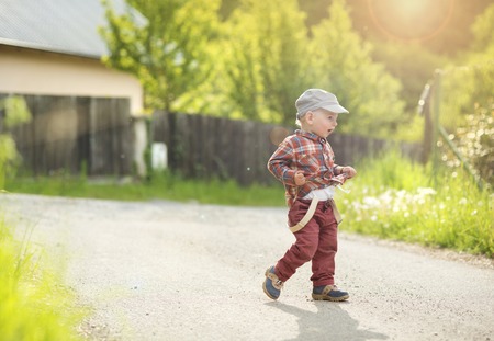 Little boy running on the countryside roadの写真素材