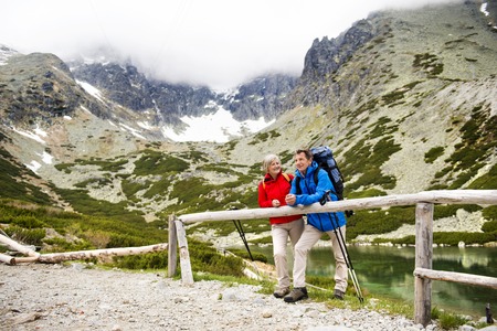 Senior tourist couple hiking at the beautiful mountainsの写真素材