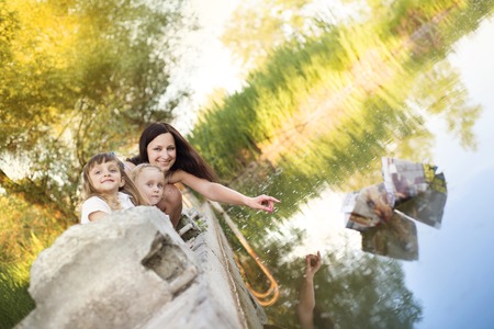Mother and her daughters spending time at lakeの写真素材
