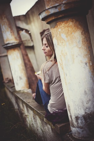 Outdoor portrait of beautiful woman posing by the old houseの写真素材