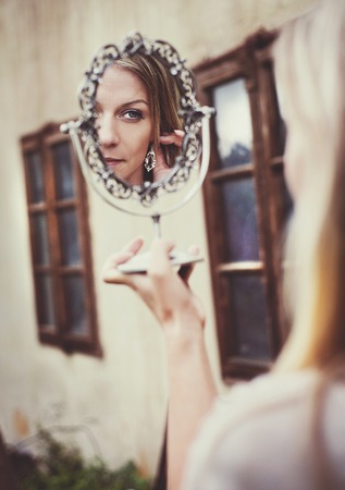 Outdoor portrait of beautiful woman posing by the old houseの写真素材