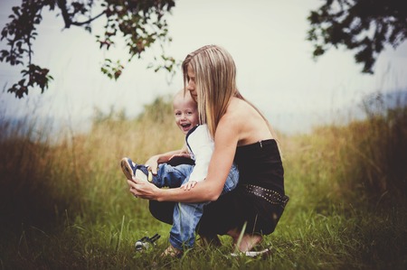Happy young mother having fun with her son in natureの写真素材
