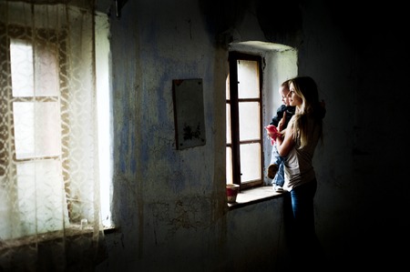 Happy young mother with her son in old houseの写真素材