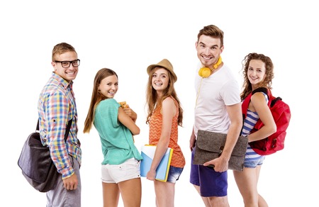 Group of happy young teenager students standing and smiling with books and bags isolated on white background の写真素材