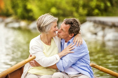 Senior couple paddling on boat on mountain tarnの写真素材