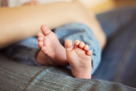 Mother playing with baby feet at homeの写真素材