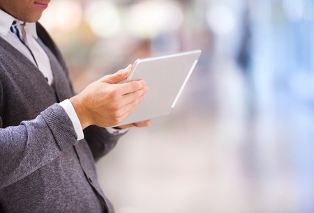 Detail of man hands holding tablet in shopping centreの写真素材