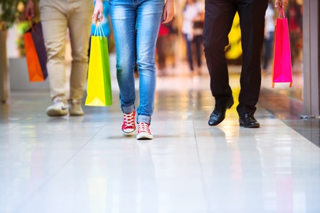Detail of legs of young couple with bags in shopping mallの写真素材