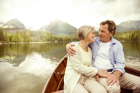 Senior couple hugging on boat on mountain tarnの写真素材