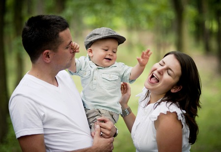 Happy young family spending time together in green nature.の写真素材