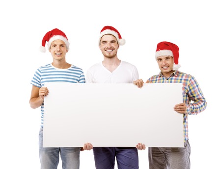 Three young men in santa hats with copy space, isolated on white backgroundの写真素材