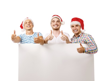 Three young men in santa hats with copy space, isolated on white backgroundの写真素材