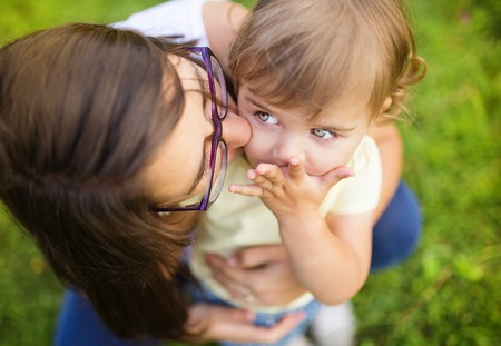 Portrait of happy little daughter and her mother in the parkの写真素材