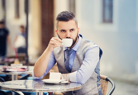 Modern hipster businessman drinking espresso coffee in the city cafe during lunch timeの写真素材