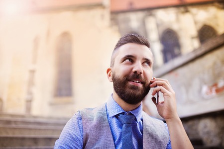 Handsome hipster modern businessman using smart phone in the cityの写真素材