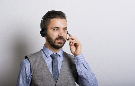 Call center operator isolated on white. Young handsome hipster man with headset.