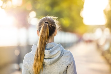 Young sporty woman walking on the city quay in the morning.の写真素材