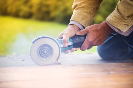 Detail of carpenters hand grinding wooden planks
