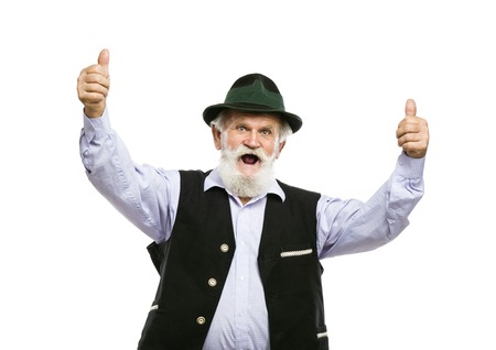 Portrait of old bearded bavarian man in traditional hat with thumbs up isolated on white background