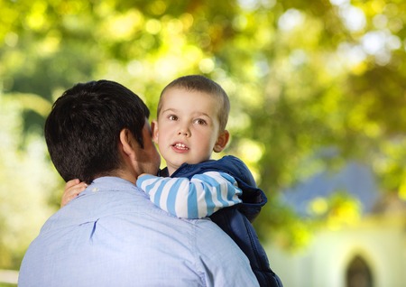 Father and son spending time together in sunny nature, son is hugging fatherの写真素材