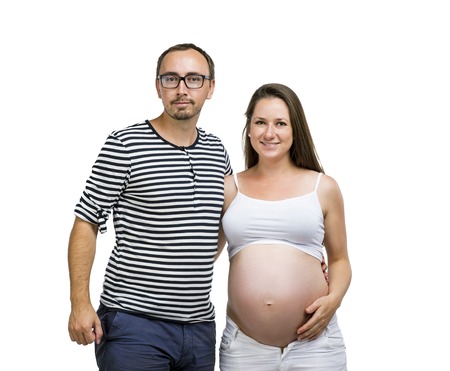 Portrait of young pregnant couple posing in studio, isolated on white backgroundの写真素材