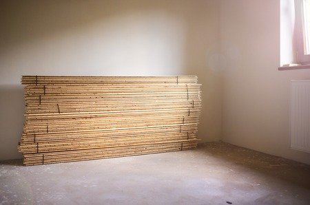 Stack of plywood ready for floor installation in new houseの写真素材