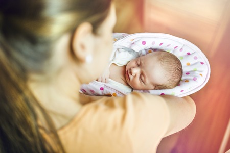 Young mother with newborn baby at home.の写真素材