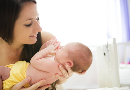 Happy mother with baby girl inside of room.の写真素材