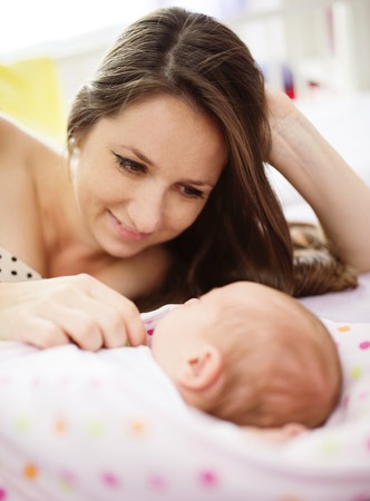 Happy mother with baby girl inside of room.の写真素材