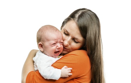 Crying child with mother isolated on white background in studioの写真素材