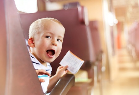 Boy travelling in retro train. He is holding train ticket.の写真素材