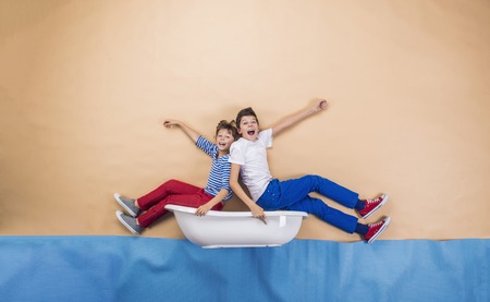 Joyful kids as sailors on the sea. Studio shot on a beige background.の写真素材