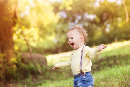 Little boy playing and having fun outside in a parkの写真素材