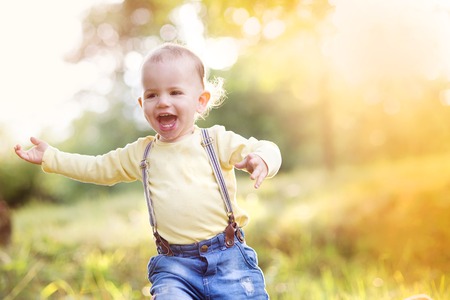 Little boy playing and having fun outside in a parkの写真素材