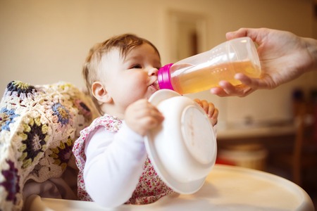 Young mother and her little daughter having breakfast togetherの写真素材