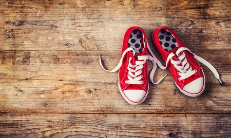 Pair of red sneakers on a floor. Studio shot on a wooden background.の写真素材