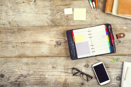 Mix of office supplies and gadgets on a wooden table background. View from above.の写真素材