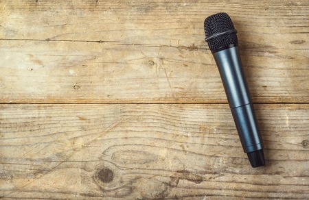 Microphone on a wooden office desk background. View from above.の写真素材