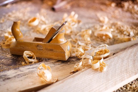 Wood planer, wooden planks and shavings at carpenters workshopの写真素材