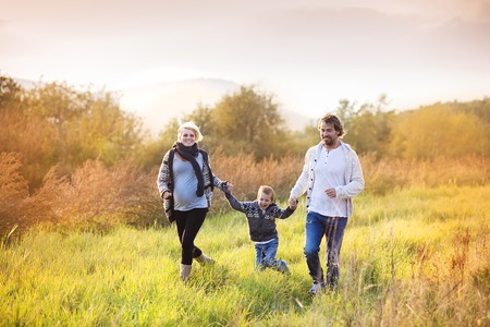 Happy young family spending time together outside in green nature.の写真素材