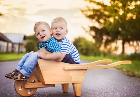 Cute little boys playing and having fun outside on a streetの写真素材